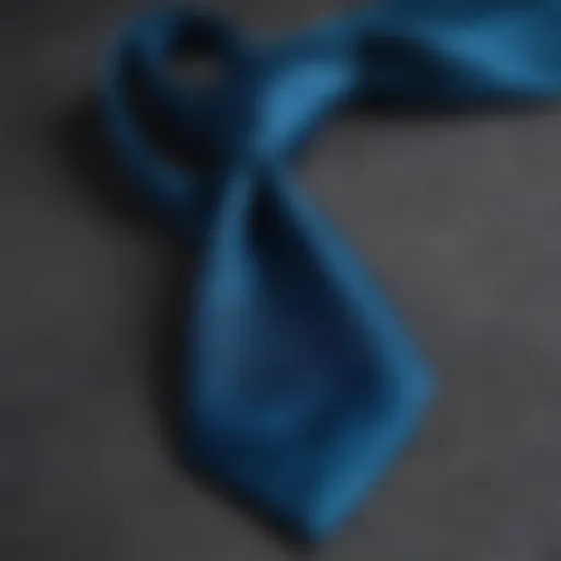 A close-up of a peacock blue tie against a textured fabric background